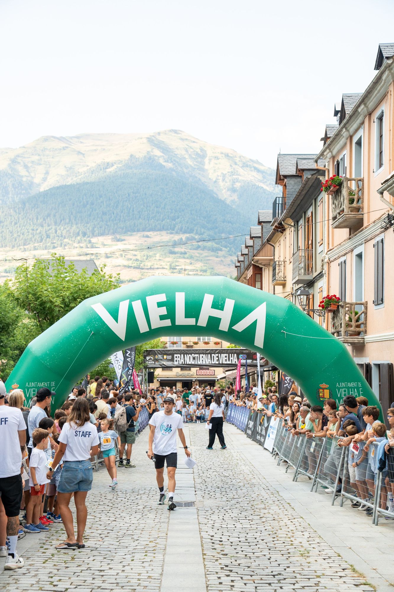 Salida de una carrera infantil bajo el arco de Vielha, con las montañas al fondo