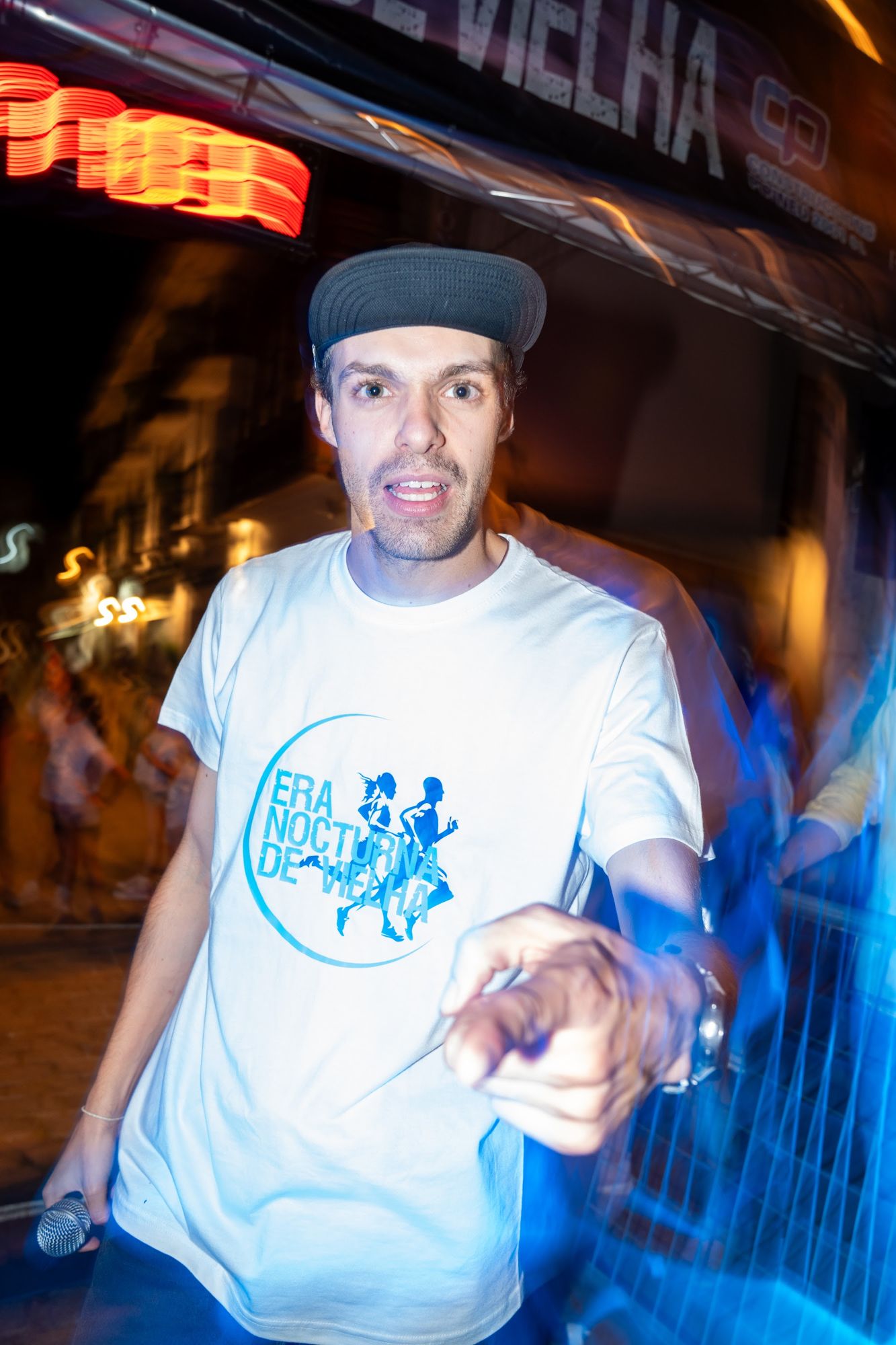 El speaker de la carrera señalando a cámara, de noche