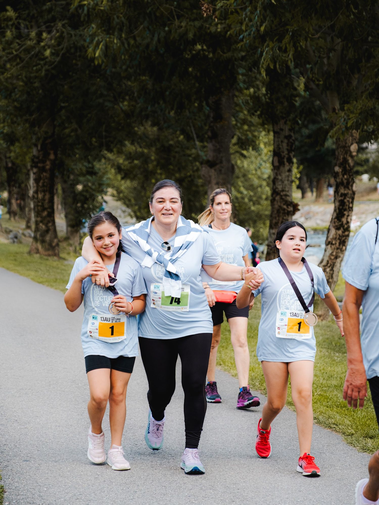 Una adulta y dos niñas corriendo juntas
